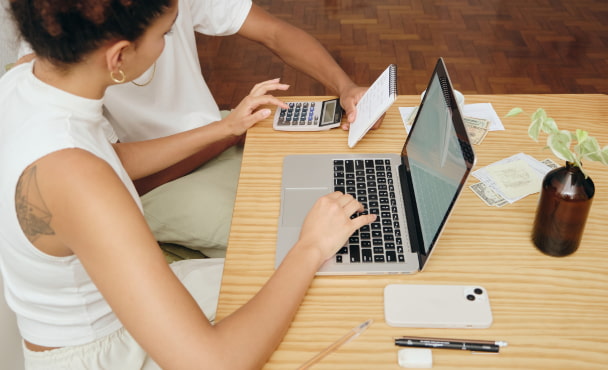 University student planning a weekly budget with calculator and notes.