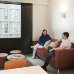 Two students in living room in off campus student accommodation.