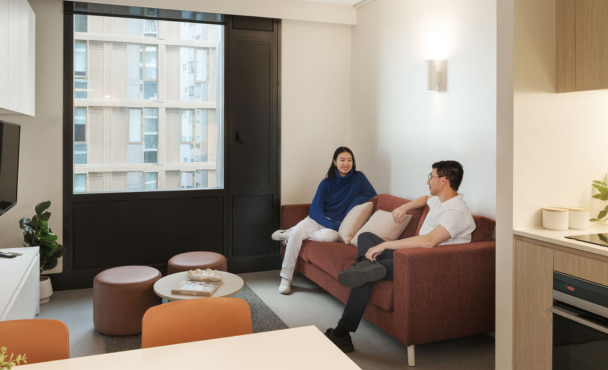 Two students in living room in off campus student accommodation.
