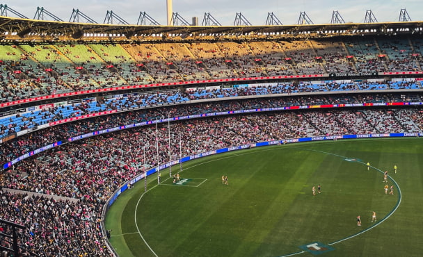Melbourne Cricket Ground, a large stadium filled with lots of people watching an AFL game