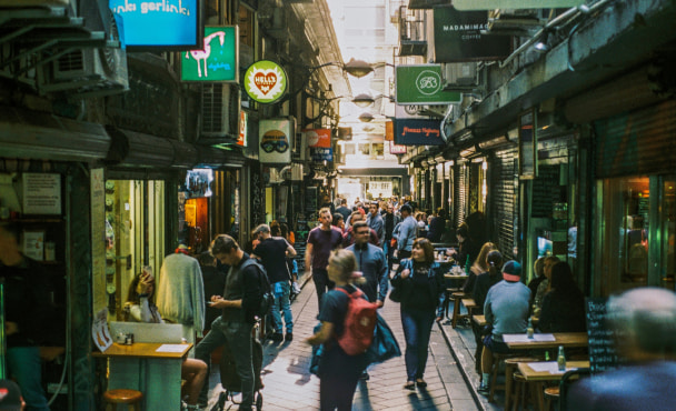 People walking through a laneway filled with restaurants and bars in Melbourne, Australia