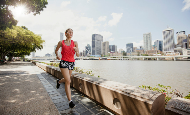Young woman dressed in sports clothing going for a jog along Brisbane Southbank.