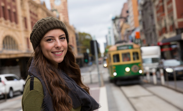 Woman in Melbourne city with tram in background.
