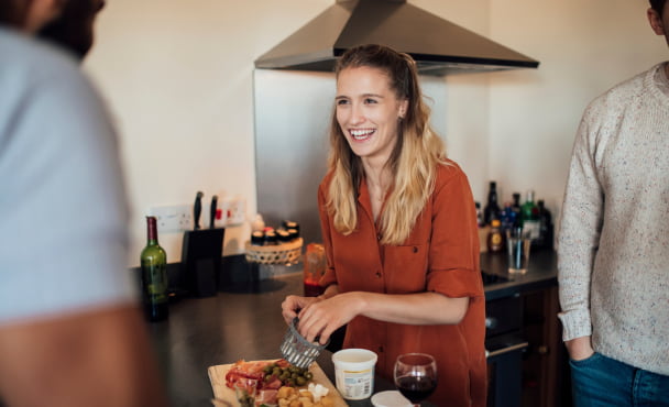 Group of friends in their 20s cooking at home in their flat.