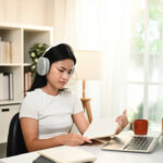 A teenage girl looks confused while studying online at home, struggling to understand difficult homework on her laptop