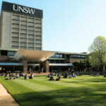 A group of people sitting on top of a lush green field at UNSW University of New South Wales Sydney Main Library