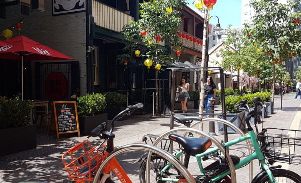 Outdoor laneway scene with bikes, cafes and pedestrians, representing student life near UTS and nearby accommodation.