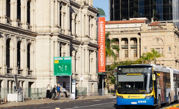 Exterior building facade of Griffith University in Brisbane, with city bus going past.