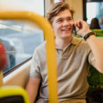 Young man using a smartphone while travelling on the tram in Melbourne, Australia.