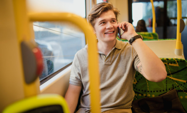 Young man using a smartphone while travelling on the tram in Melbourne, Australia.